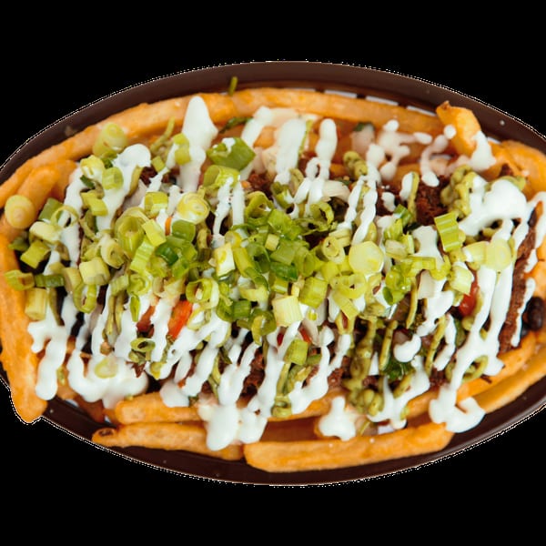 French fries loaded with meat, white sauce, and chopped green onions in a brown basket.