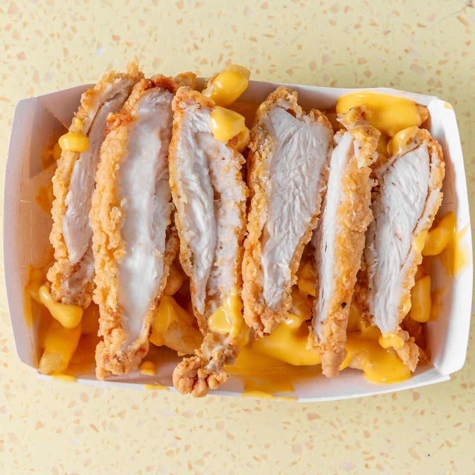 Crispy fried chicken strips and golden fries smothered in melted cheese sauce.